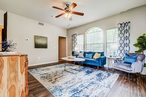 a living room with a ceiling fan and a blue couch